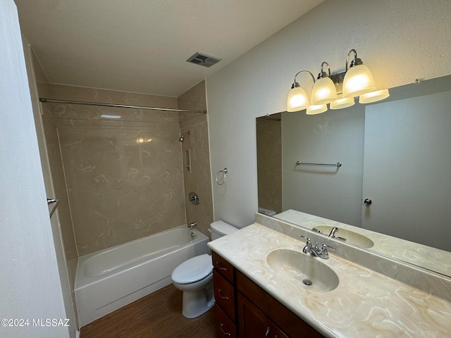 full bathroom with vanity, tiled shower / bath combo, wood-type flooring, and toilet