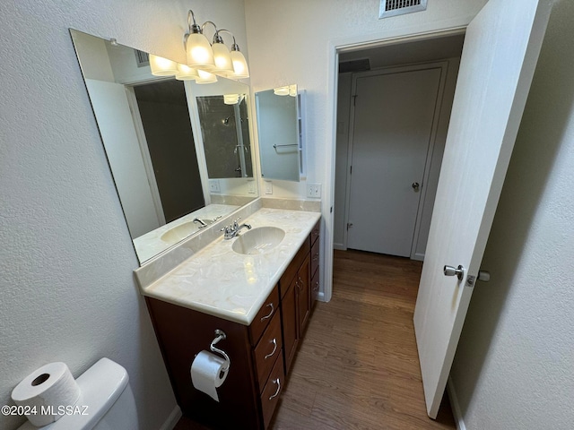 bathroom featuring toilet, hardwood / wood-style floors, and vanity