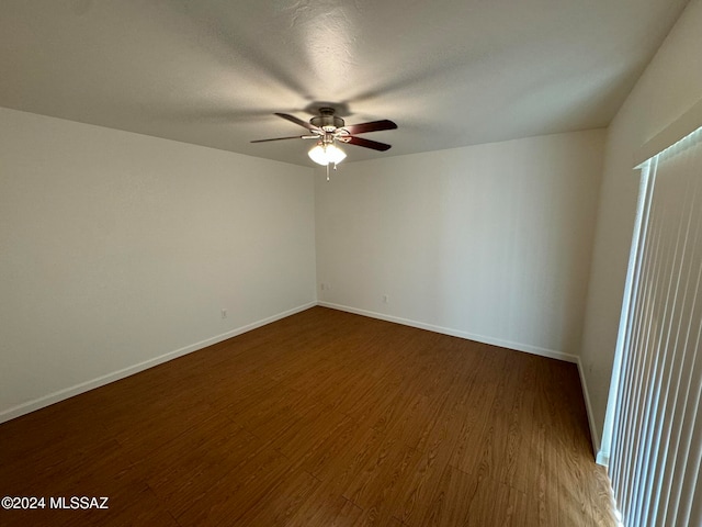 empty room with dark wood-type flooring and ceiling fan