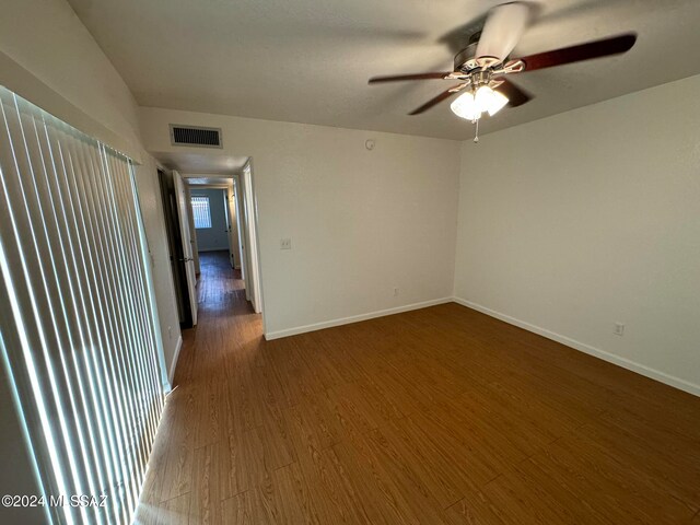 unfurnished room featuring dark hardwood / wood-style floors and ceiling fan