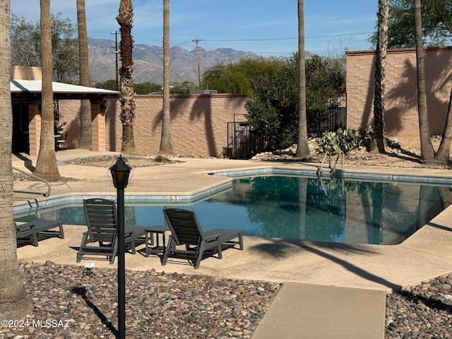 view of swimming pool featuring a patio area and a mountain view