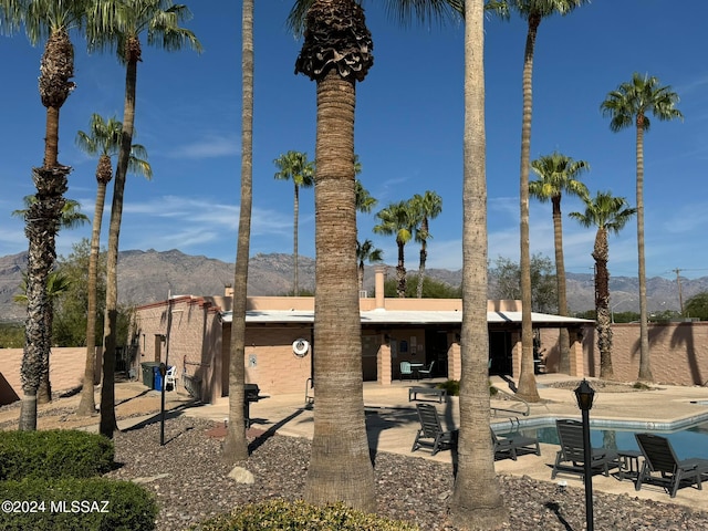 rear view of house with a mountain view and a patio