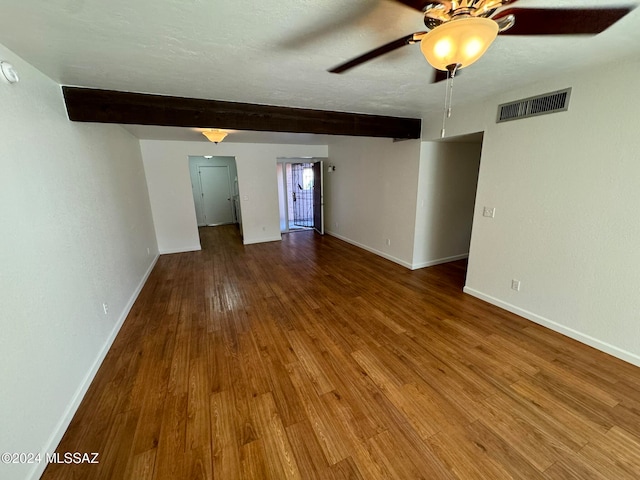 unfurnished room with beam ceiling, a textured ceiling, wood-type flooring, and ceiling fan