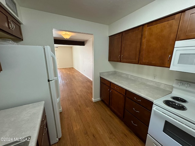 kitchen featuring light hardwood / wood-style flooring, dark brown cabinets, and white appliances