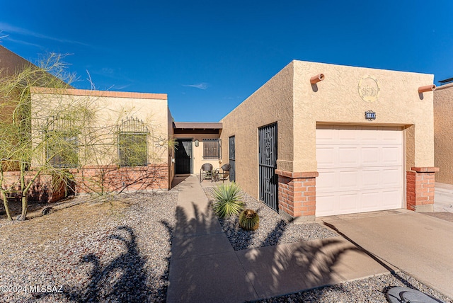 pueblo-style house featuring a garage