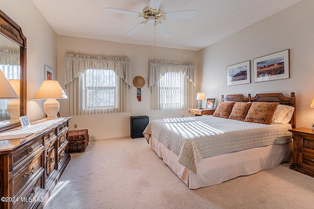 carpeted bedroom with ceiling fan and a textured ceiling