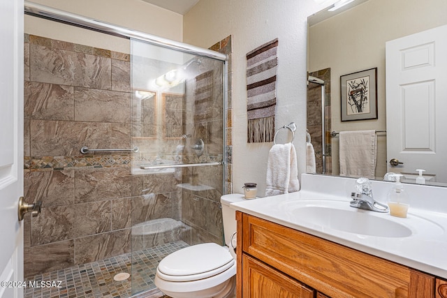 bathroom with vanity, a shower with shower door, and toilet