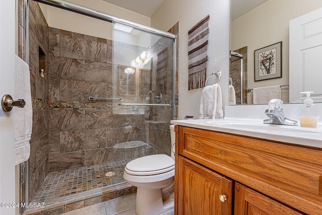 bathroom with tile patterned flooring, vanity, toilet, and a shower with door