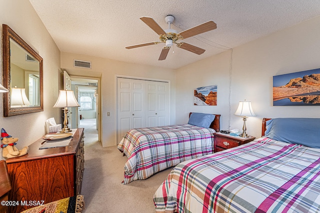 bedroom with carpet flooring, a textured ceiling, a closet, and ceiling fan