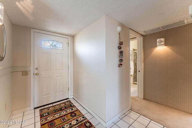 tiled entrance foyer featuring a textured ceiling