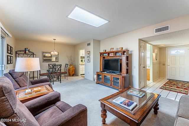 living room with light carpet and an inviting chandelier