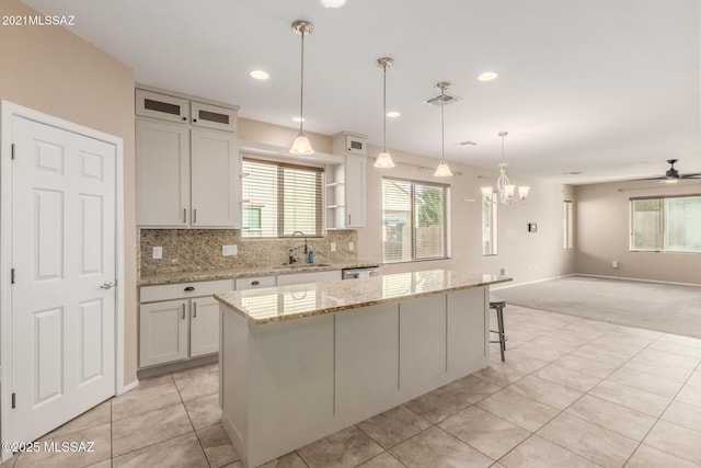 kitchen featuring a center island, pendant lighting, and white cabinets