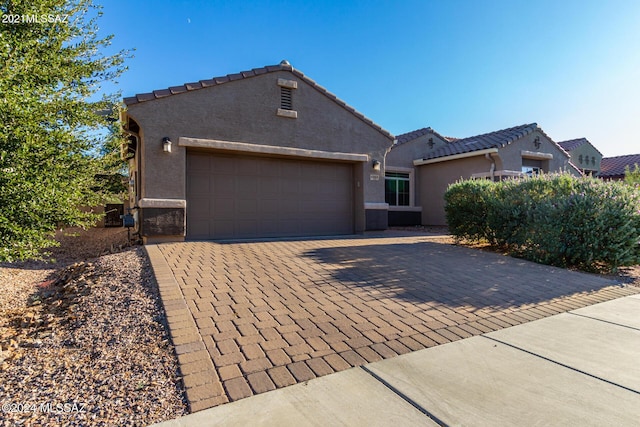 8869 W Irongate Rd, Marana, AZ 85653 - view of front facade with stucco siding, driveway, an attached garage, and a tiled roof