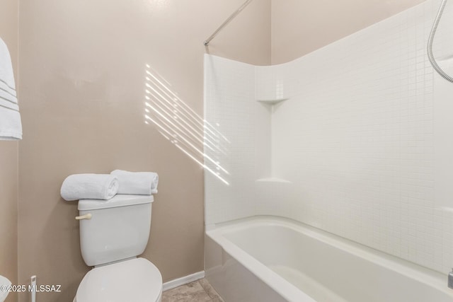 bathroom with tiled shower / bath combo and toilet