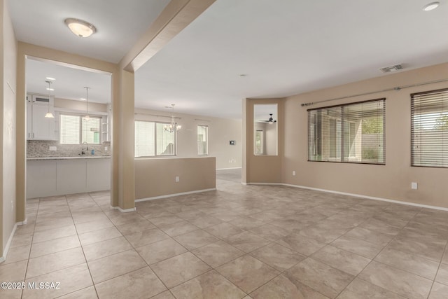 empty room featuring light tile patterned flooring, sink, and a chandelier