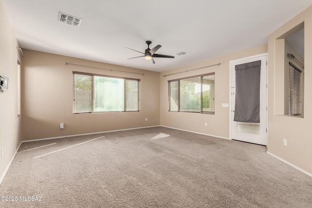 empty room featuring ceiling fan and carpet