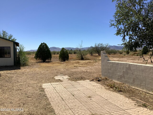 view of yard with a rural view and a mountain view