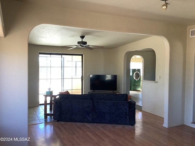 7857 W Winchester Easement, Willcox, AZ 85643 - living room featuring washer / clothes dryer, visible vents, ceiling fan, arched walkways, and wood finished floors