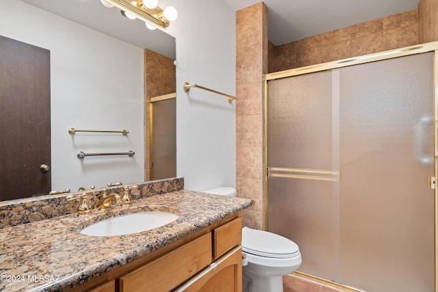 bathroom featuring an enclosed shower, vanity, and toilet