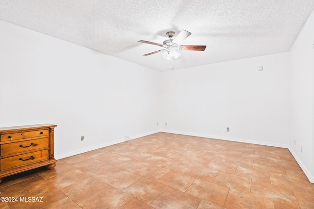 empty room featuring ceiling fan and a textured ceiling