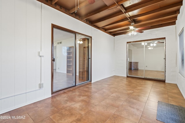 tiled empty room featuring beam ceiling, ceiling fan, and wooden ceiling