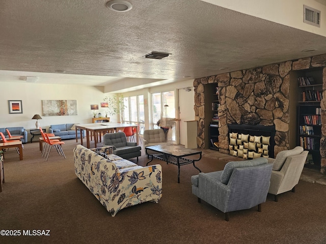 carpeted living room featuring a textured ceiling and a stone fireplace