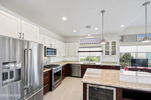 kitchen with wine cooler, stainless steel appliances, a sink, visible vents, and glass insert cabinets