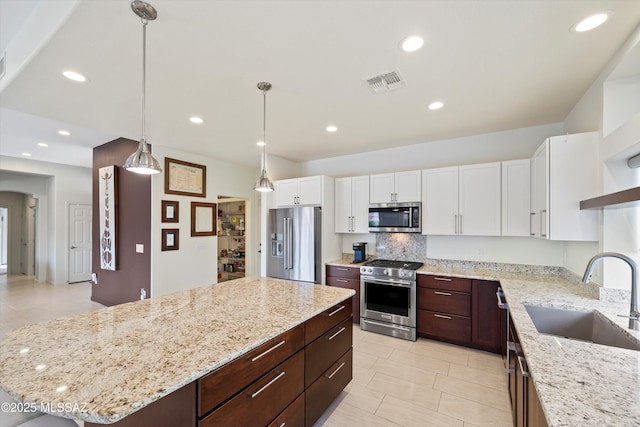 kitchen with visible vents, stainless steel appliances, white cabinetry, open shelves, and a sink