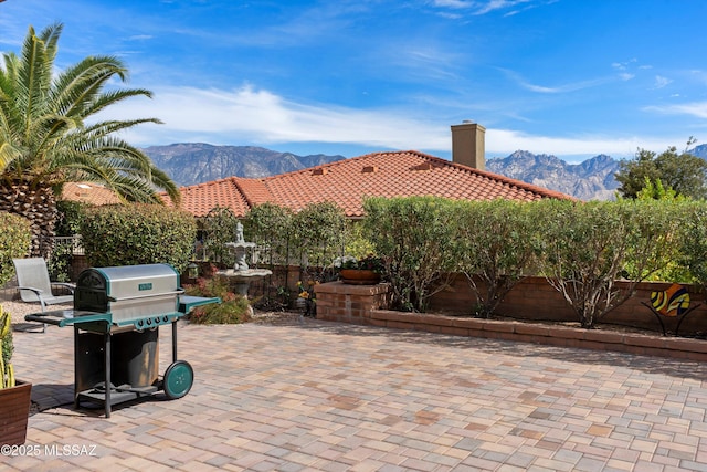 view of patio with a fenced backyard, a mountain view, and area for grilling