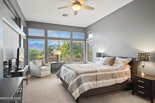 bedroom featuring light carpet, visible vents, and a ceiling fan