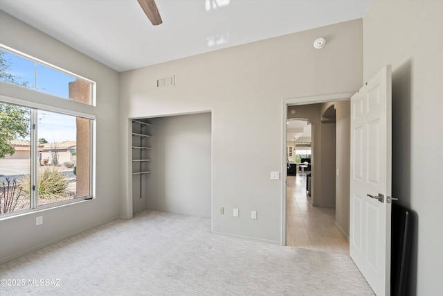 unfurnished bedroom with carpet, visible vents, and a ceiling fan