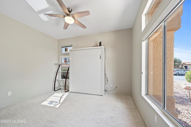 carpeted empty room featuring a ceiling fan