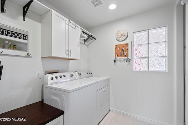 laundry room featuring visible vents, washing machine and clothes dryer, cabinet space, and baseboards