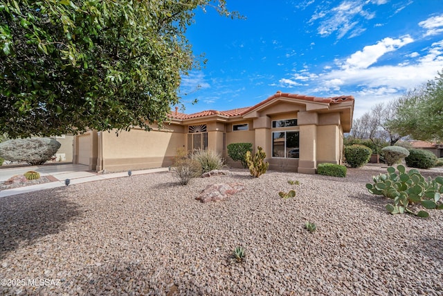 view of front of house featuring a tiled roof, an attached garage, and stucco siding