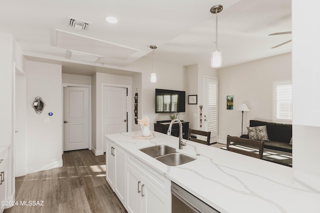 kitchen featuring sink, light stone counters, dark hardwood / wood-style floors, pendant lighting, and white cabinets