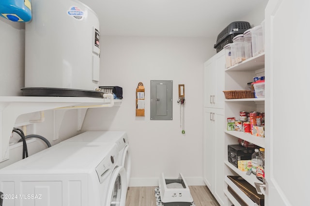 washroom with electric panel, cabinets, washing machine and dryer, and light wood-type flooring