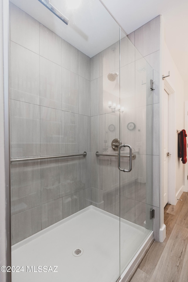 bathroom featuring hardwood / wood-style floors and a shower with door