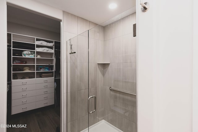 bathroom featuring wood-type flooring and an enclosed shower