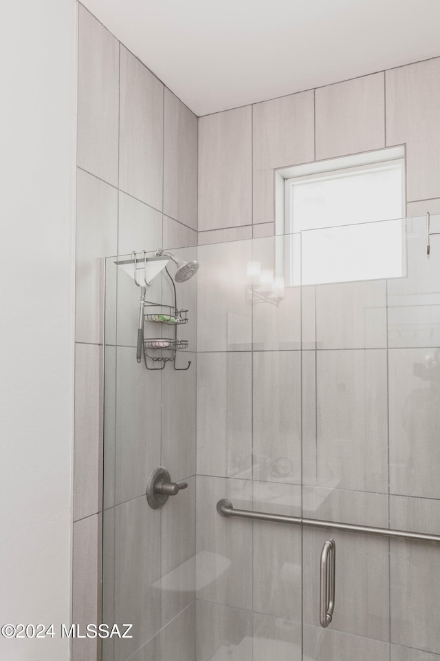 bathroom with a shower with door