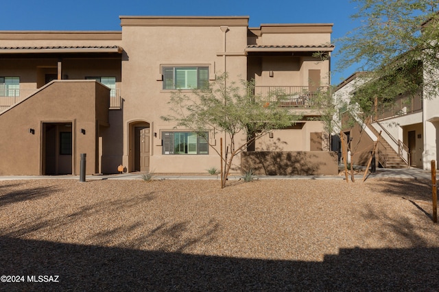 rear view of property featuring a balcony