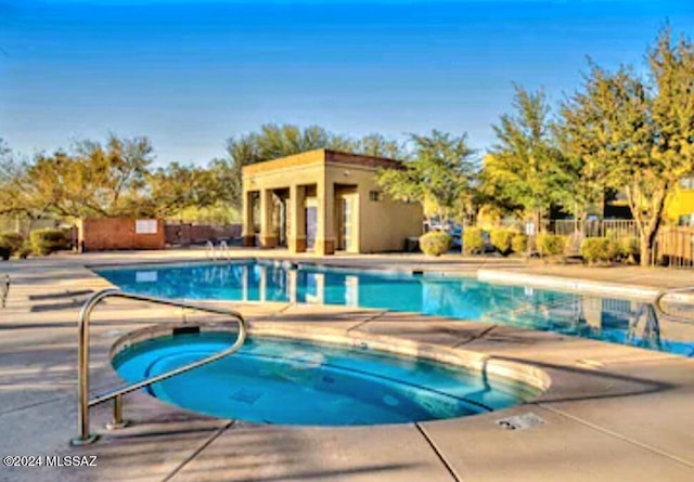 view of swimming pool featuring a patio area and a hot tub