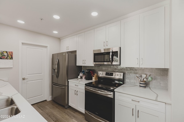 kitchen featuring backsplash, stainless steel appliances, sink, white cabinets, and dark hardwood / wood-style floors