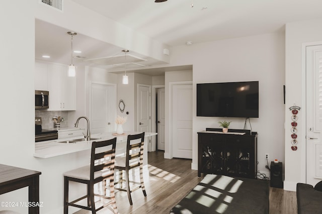 kitchen with sink, hanging light fixtures, black range with electric cooktop, dark hardwood / wood-style floors, and white cabinets