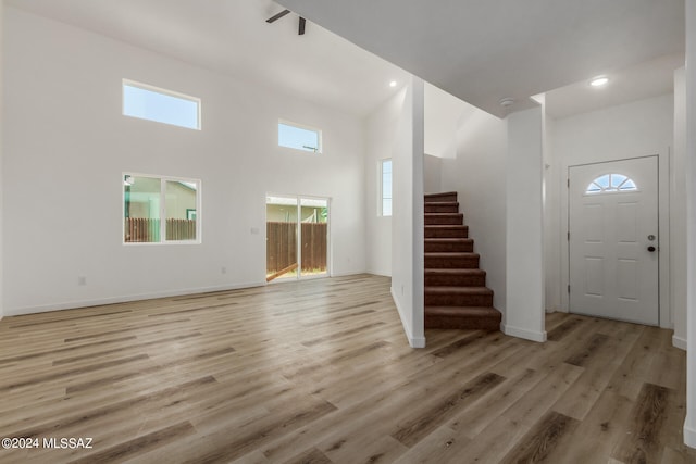 foyer entrance with a high ceiling and light wood-type flooring