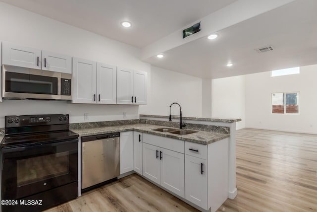 kitchen with sink, appliances with stainless steel finishes, light stone counters, and white cabinetry