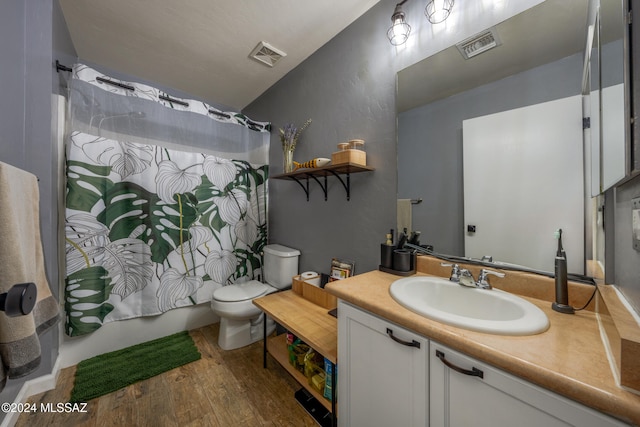 full bathroom with hardwood / wood-style floors, vanity, toilet, and shower / bath combination with curtain