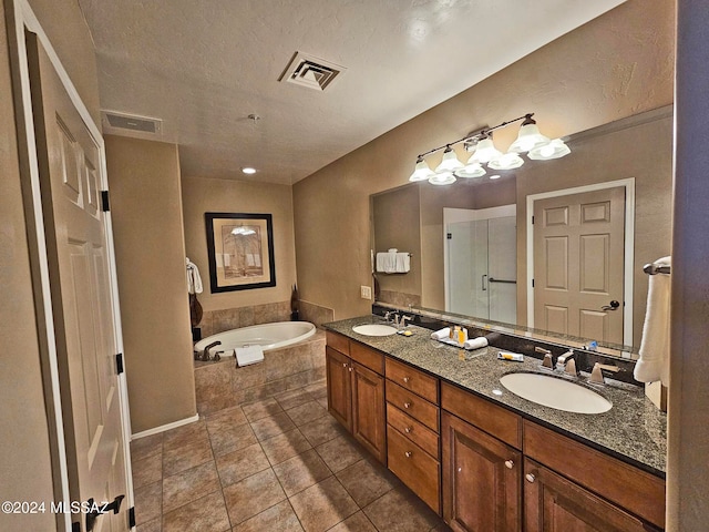 bathroom featuring a bath, double vanity, a sink, and visible vents