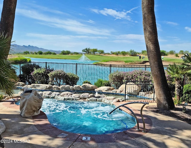 view of pool featuring a water view and fence