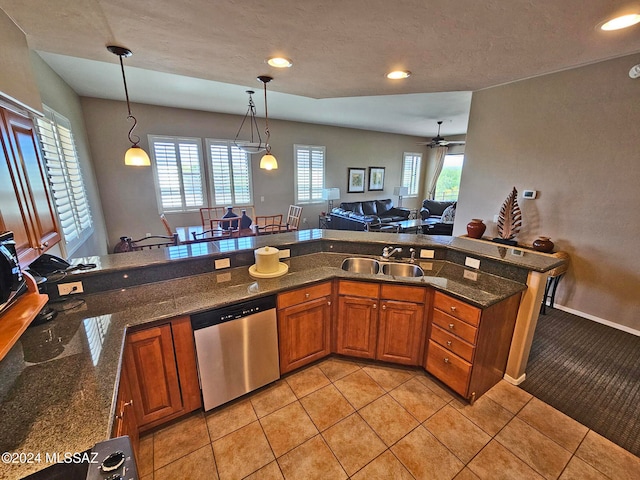 kitchen with brown cabinets, open floor plan, a sink, pendant lighting, and stainless steel dishwasher