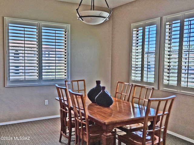 carpeted dining room with baseboards